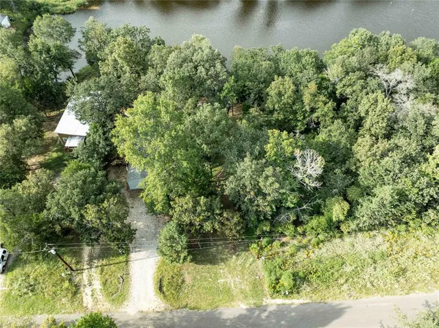 an aerial view of residential houses with outdoor space and trees