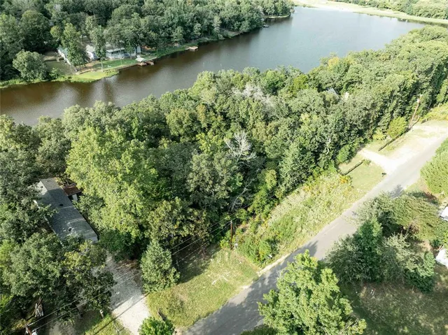 an aerial view of residential houses with outdoor space and lake view