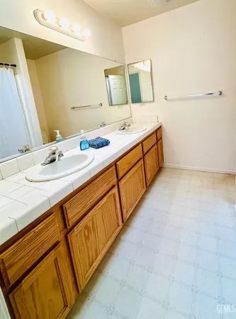 a spacious bathroom with a double vanity sink and mirror