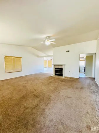 an empty room with fireplace and wooden floor