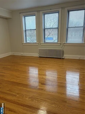 a view of a room with wooden floor and windows
