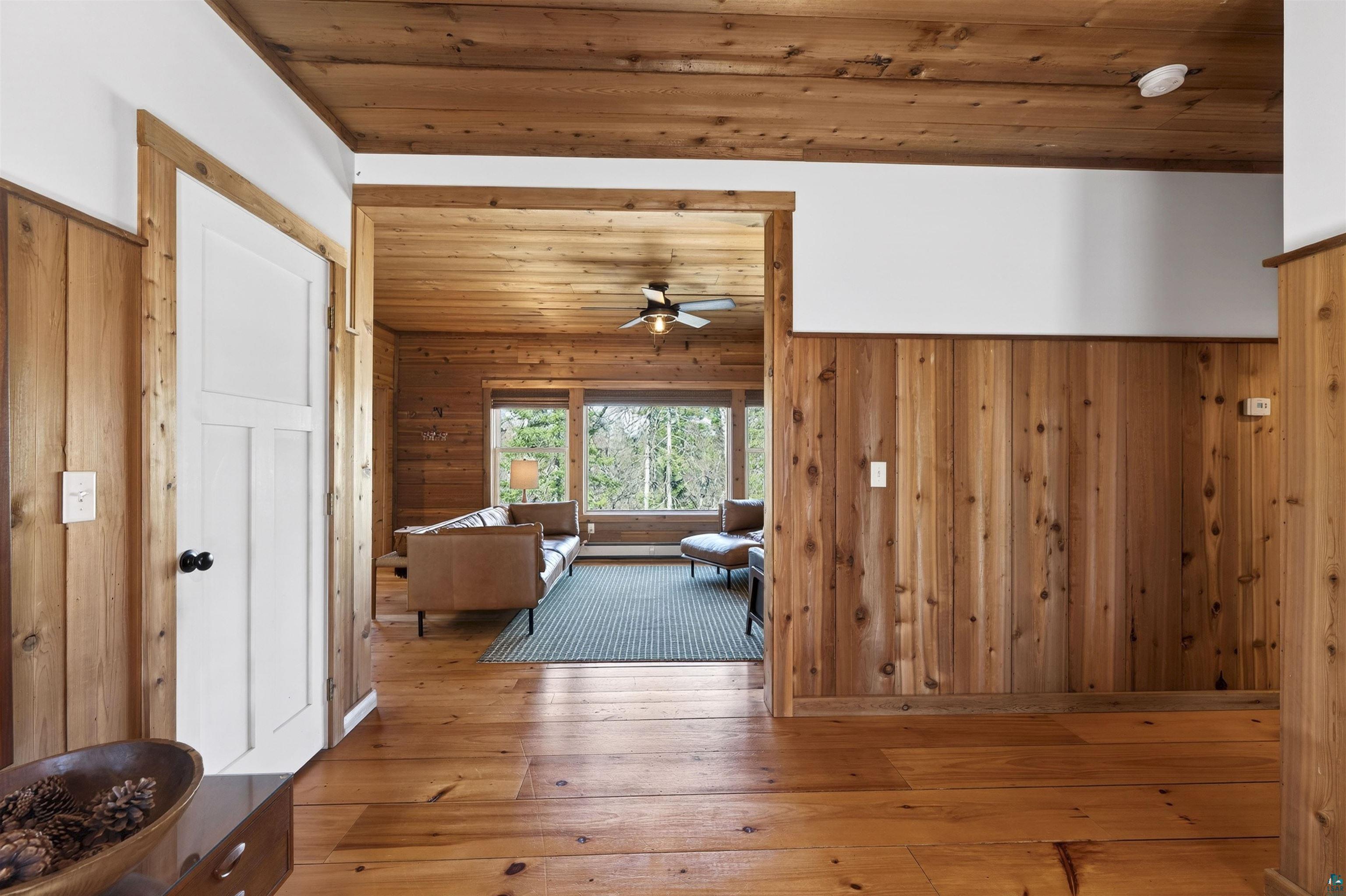 13885 Park Road Brule, WI 54820 - Photo 12 of 41 Wood-paneled interior featuring natural wood flooring, matching wood ceiling, and white trim
