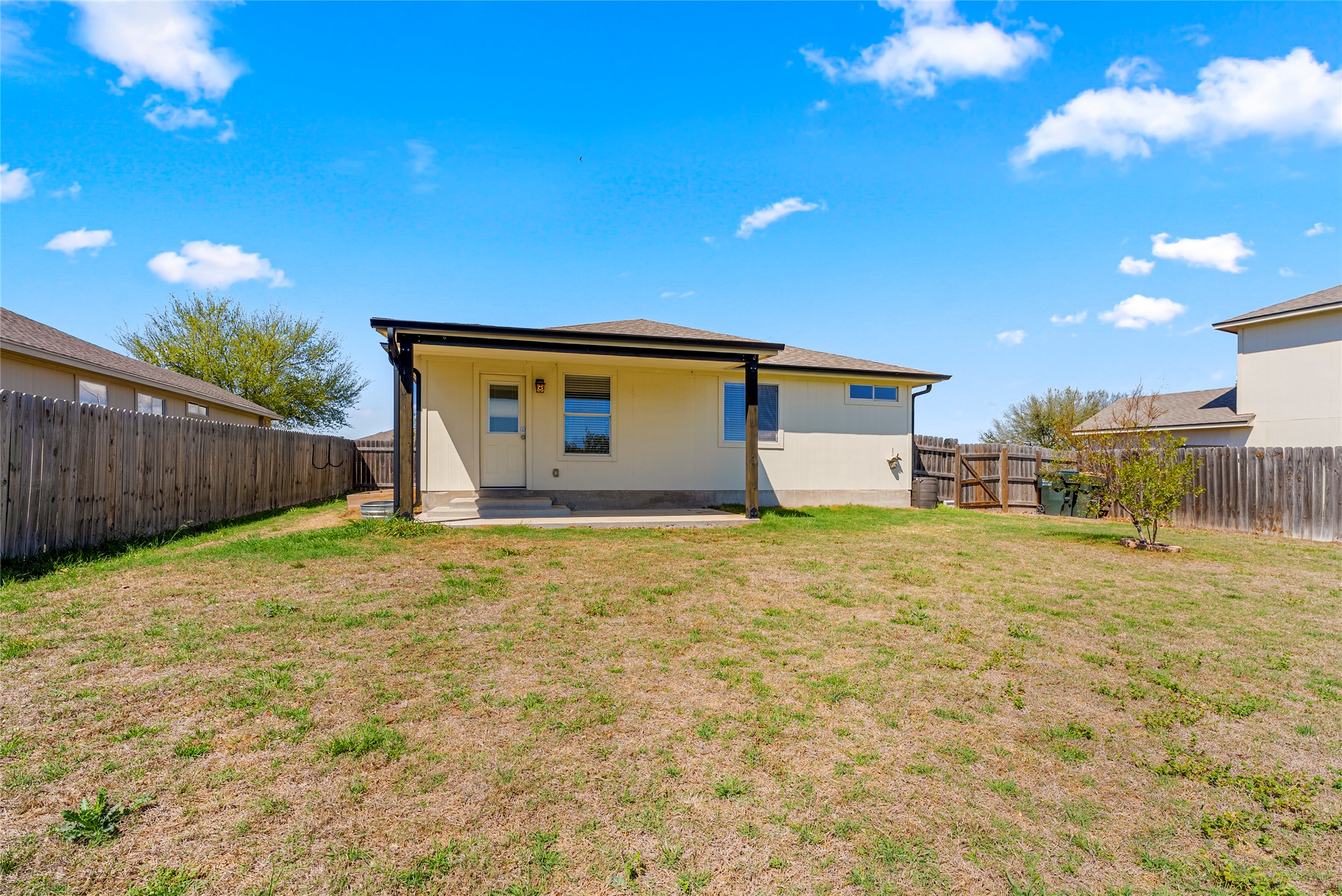 348 Atlantis Kyle, TX 78640 - Photo 16 of 17 Rear view of property featuring a patio area, a fenced backyard, and a gate