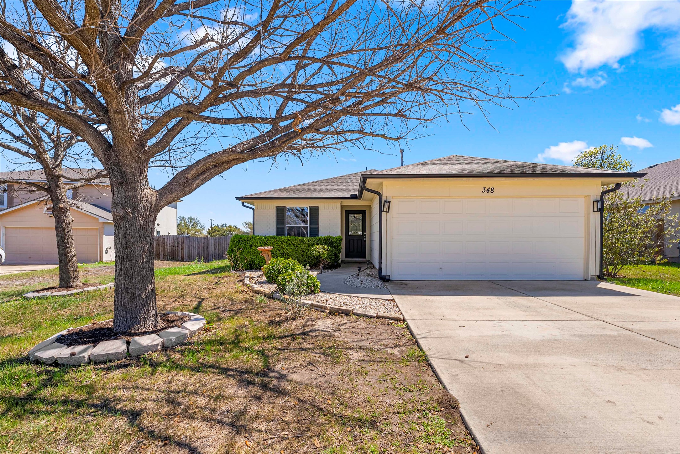 348 Atlantis Kyle, TX 78640 - Photo 2 of 17 Single story home with an attached garage, concrete driveway, and a shingled roof
