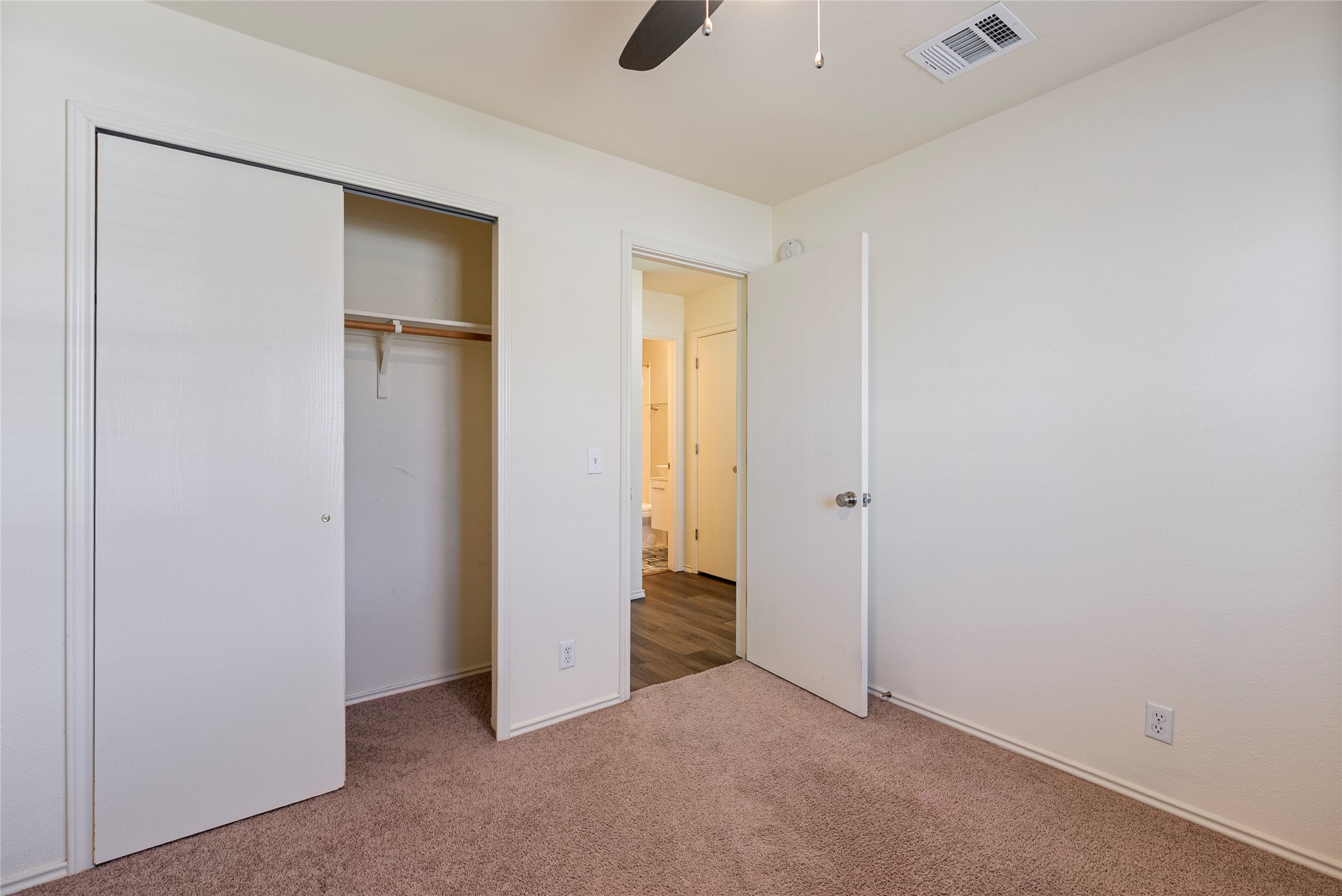 348 Atlantis Kyle, TX 78640 - Photo 6 of 17 Unfurnished bedroom featuring carpet, a closet, and a ceiling fan