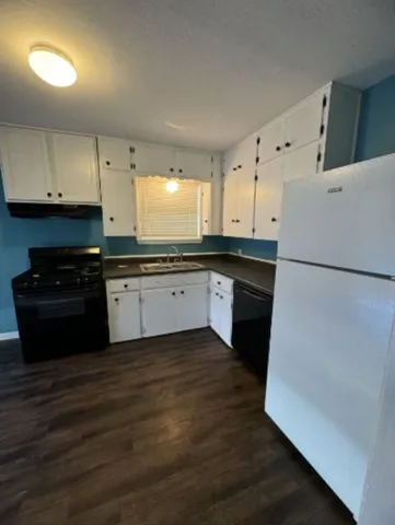 a kitchen with wooden cabinets and white appliances