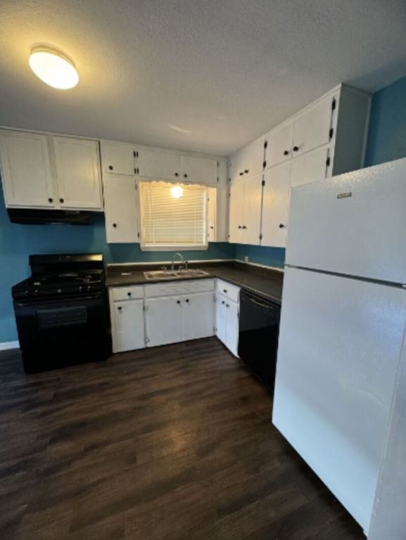 203 North Street, Unit A Kyle, TX 78640 - Photo 3 of 8 a kitchen with wooden cabinets and white appliances