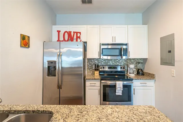 a kitchen with stainless steel appliances granite countertop a refrigerator stove and oven