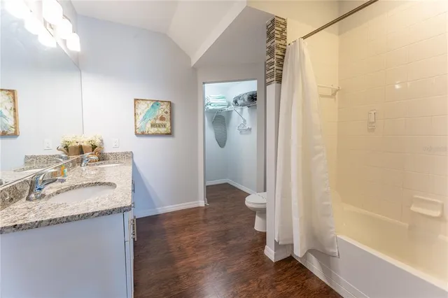 a bathroom with a granite countertop sink toilet and shower