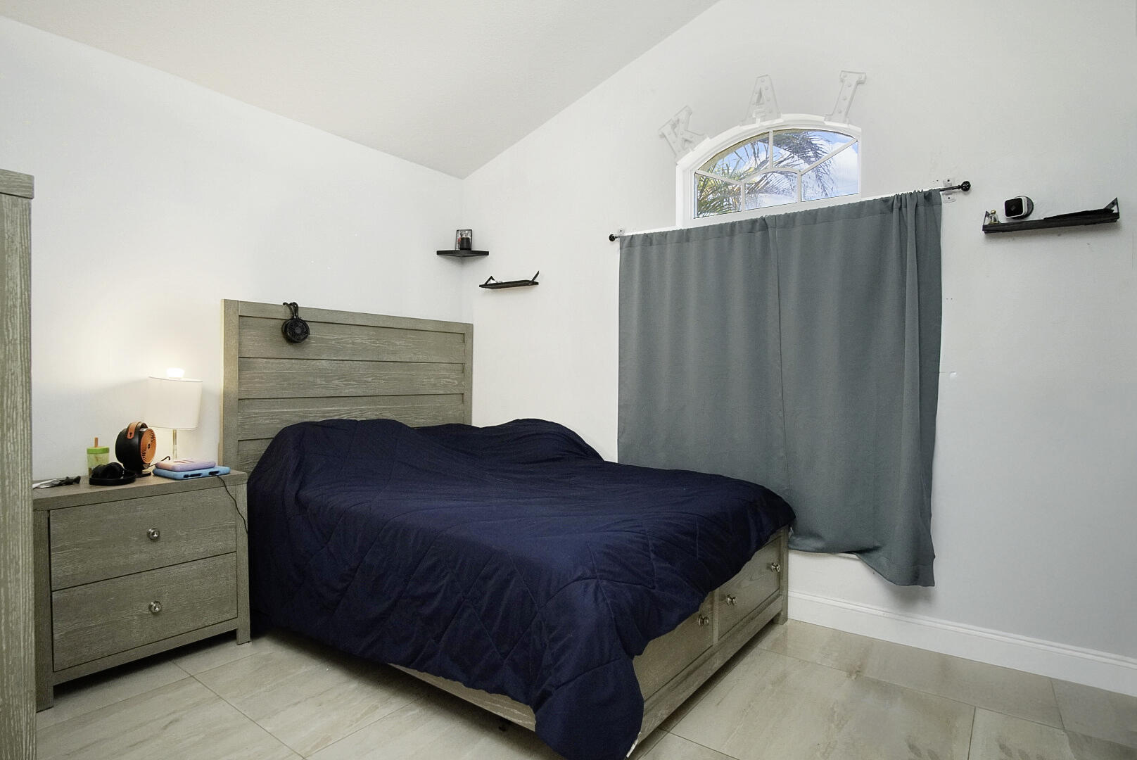 2619 Southwest Fair Isle Road Port St. Lucie, FL 34987 - Photo 18 of 33 a bedroom with a bed and a chandelier