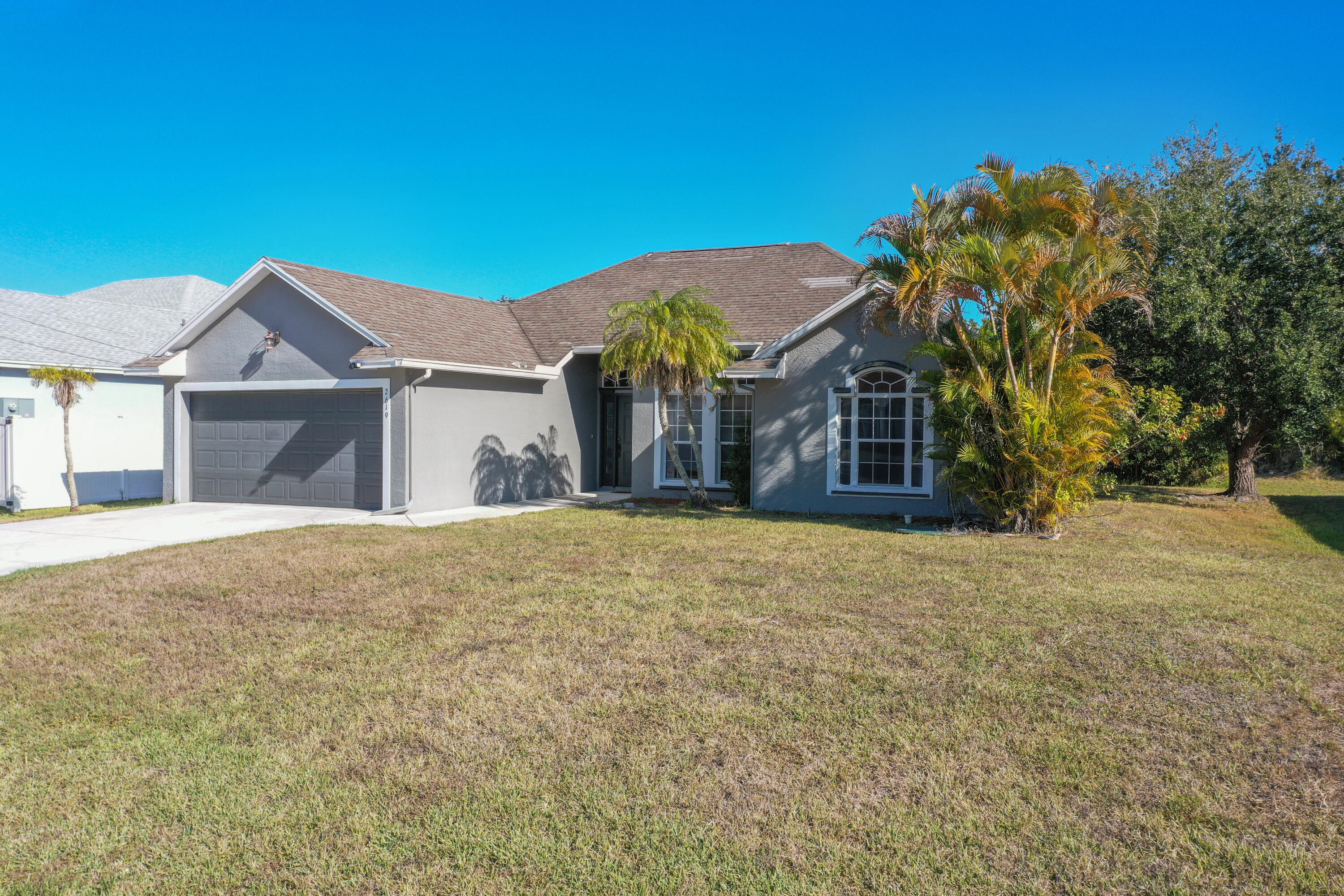 2619 Southwest Fair Isle Road Port St. Lucie, FL 34987 - Photo 25 of 33 a front view of a house with a yard and garage