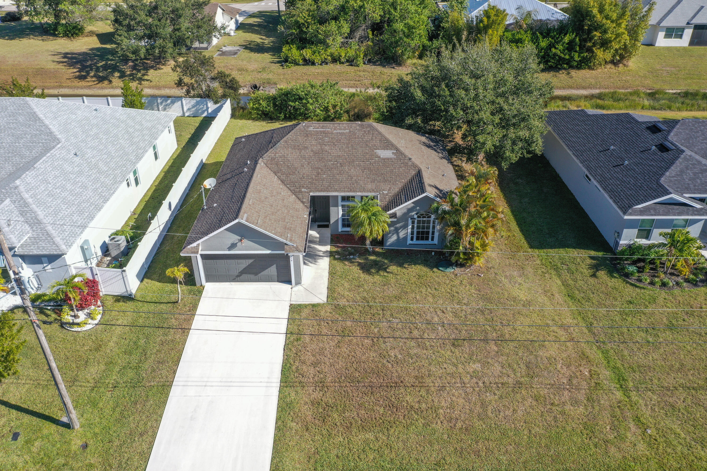 2619 Southwest Fair Isle Road Port St. Lucie, FL 34987 - Photo 26 of 33 an aerial view of a house with swimming pool and large trees