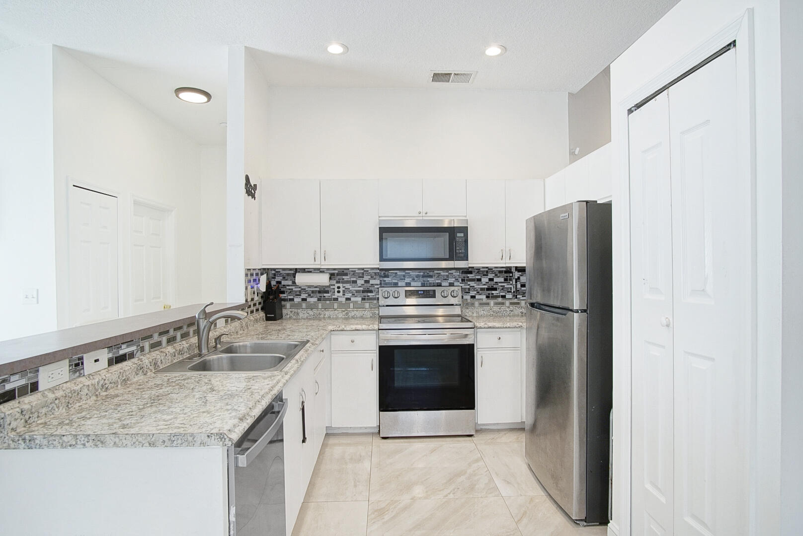 2619 Southwest Fair Isle Road Port St. Lucie, FL 34987 - Photo 3 of 33 a kitchen with a sink stove and refrigerator