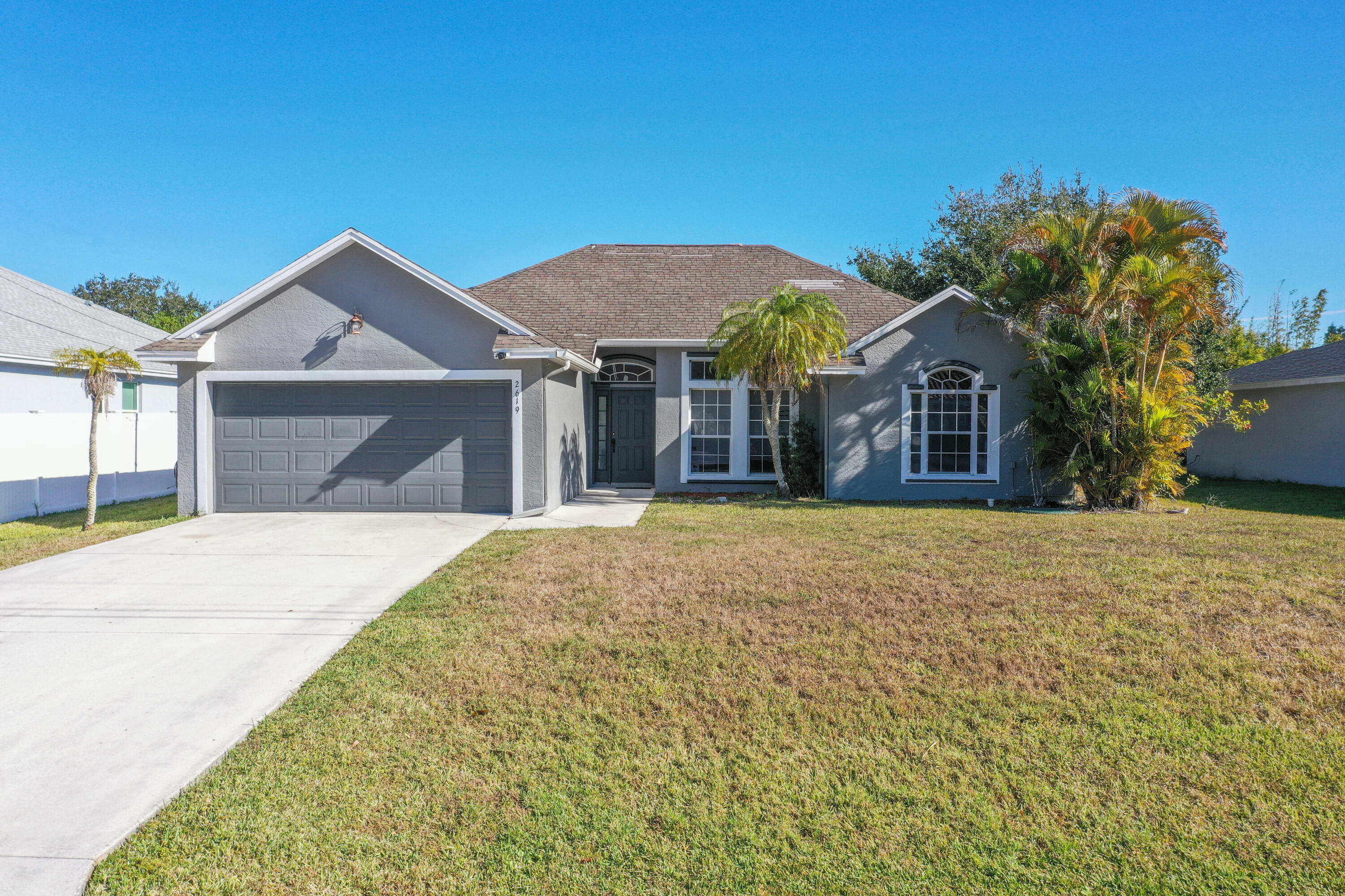 2619 Southwest Fair Isle Road Port St. Lucie, FL 34987 - Photo 32 of 33 a front view of a house with a yard and garage
