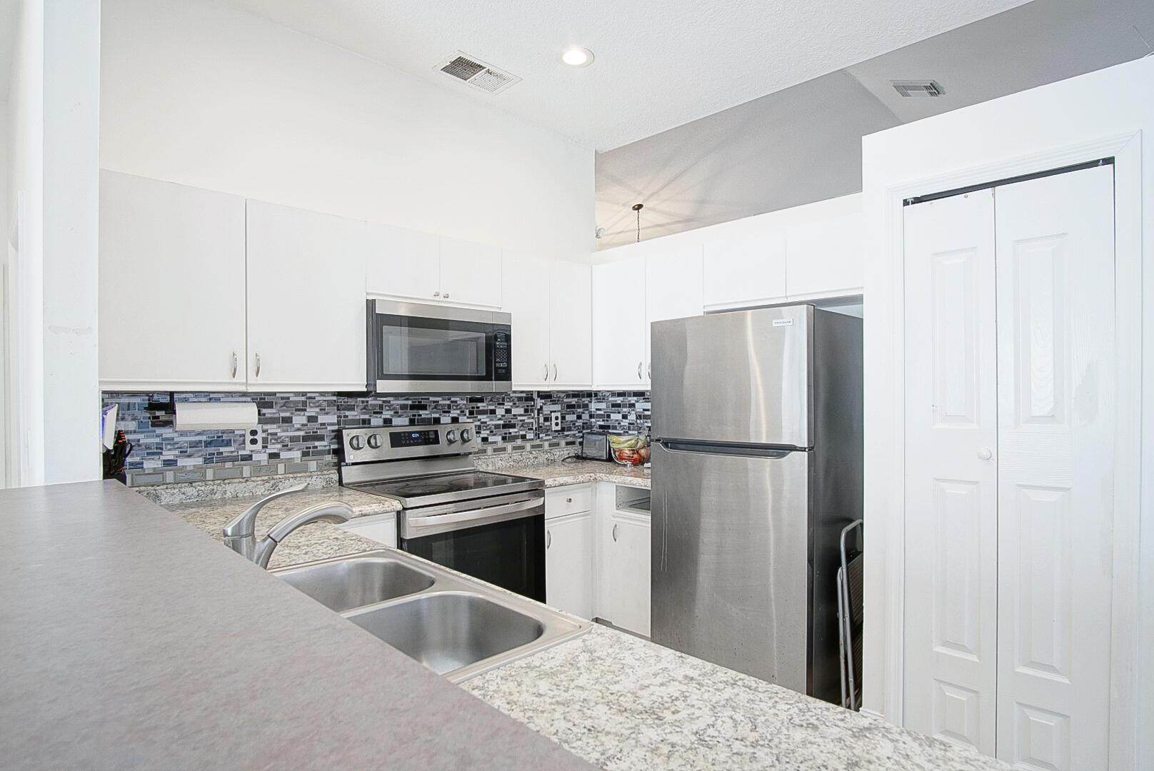 2619 Southwest Fair Isle Road Port St. Lucie, FL 34987 - Photo 4 of 33 a kitchen with a refrigerator sink and stainless steel appliances