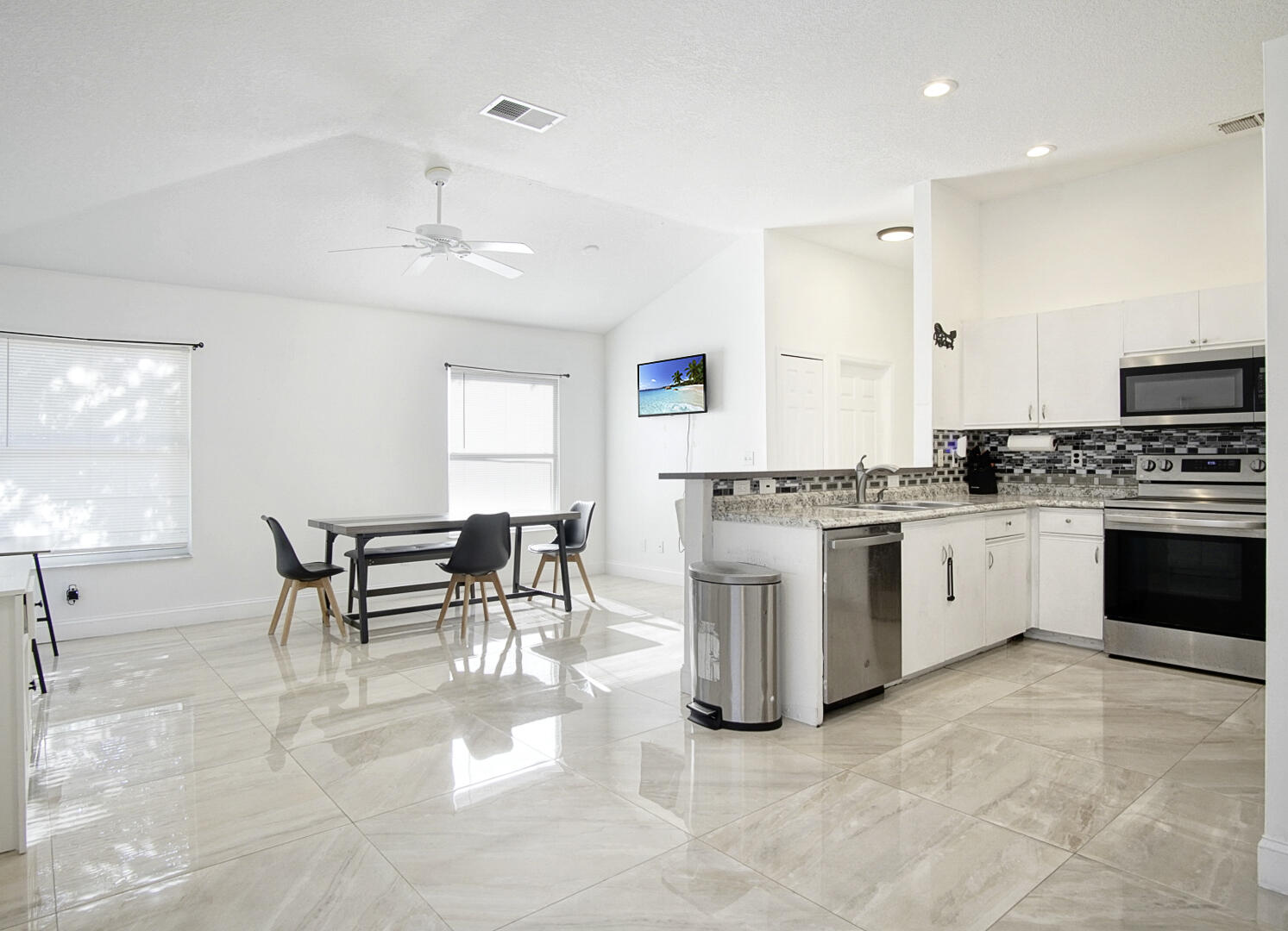 2619 Southwest Fair Isle Road Port St. Lucie, FL 34987 - Photo 7 of 33 a white kitchen with granite countertop white cabinets and white appliances