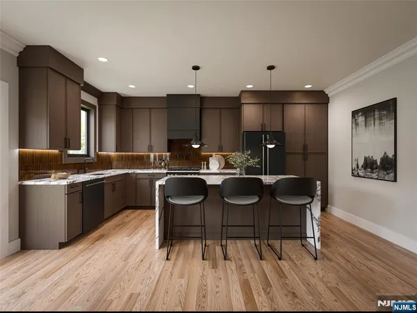 a kitchen with kitchen island granite countertop a sink cabinets and stainless steel appliances