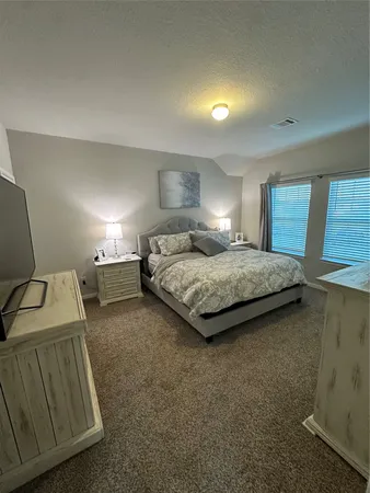 a bedroom with a bed and a night stand