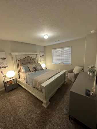 a bedroom with bed couch and window