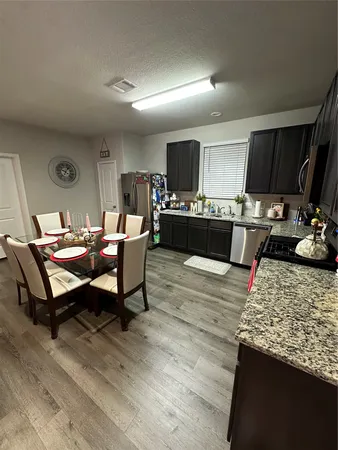 a living room with furniture a flat screen tv and kitchen view