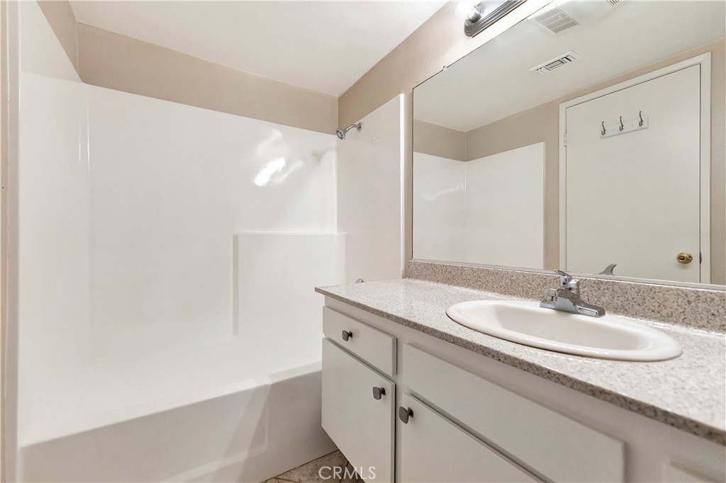 2670 West Segerstrom Avenue, Unit F Santa Ana, CA 92704 - Photo 15 of 28 a bathroom with a granite countertop sink and a mirror