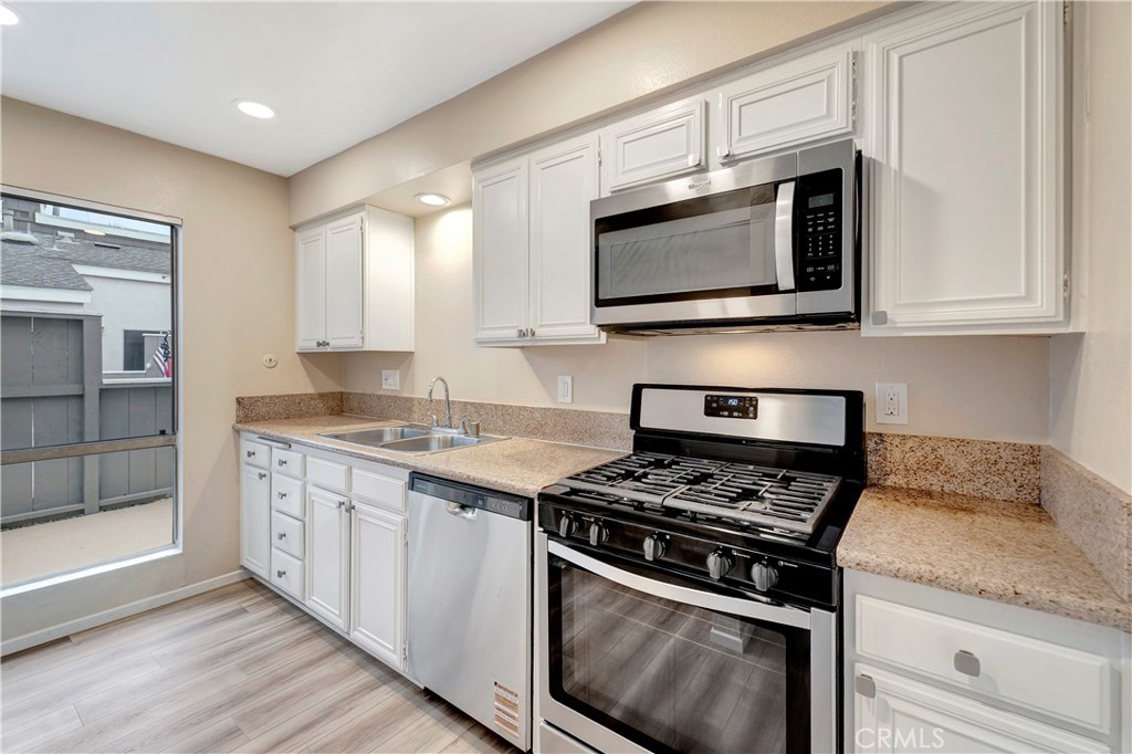 2670 West Segerstrom Avenue, Unit F Santa Ana, CA 92704 - Photo 8 of 28 a kitchen with stainless steel appliances granite countertop a stove microwave and sink