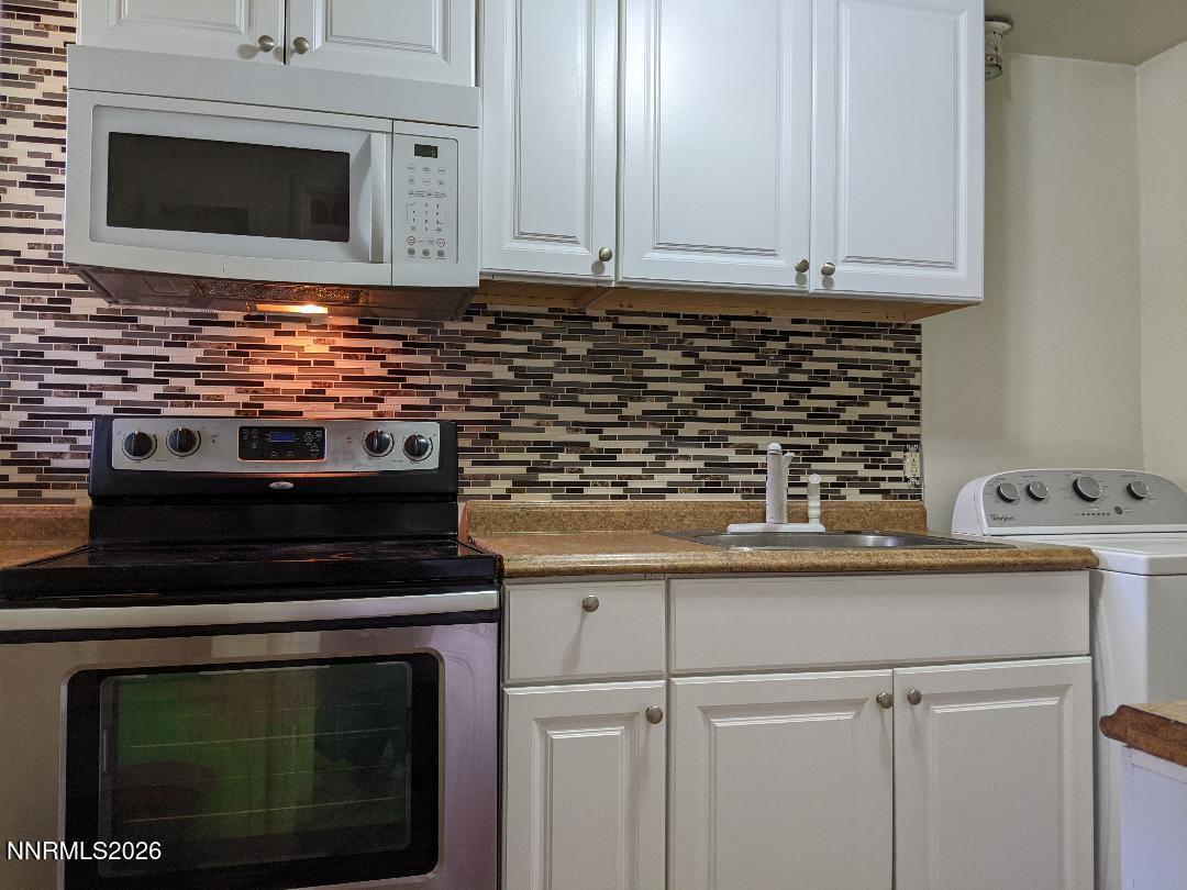 670 Denslowe Drive Reno, NV 89512 - Photo 5 of 12 a kitchen with stainless steel appliances granite countertop white cabinets and a stove top oven