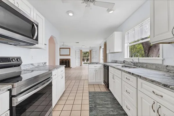 a large kitchen with a stove top oven and sink