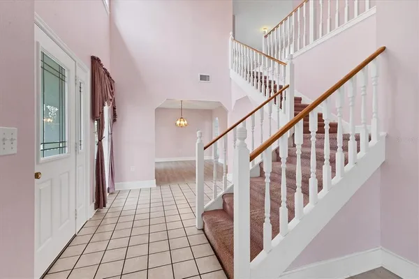 a view of staircase with lots of frames on wall and wooden floor