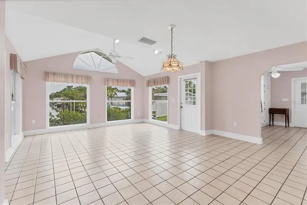 a view of an empty room with window and chandelier