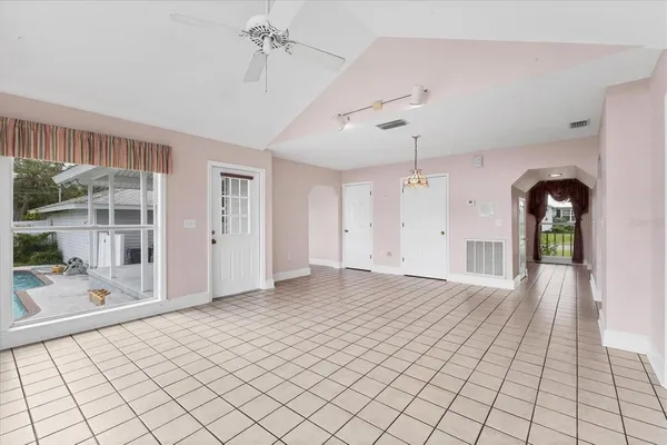 a view of an empty room with wooden floor fireplace and a window