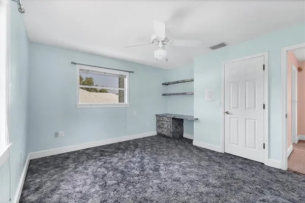 a large white kitchen with a window and cabinets