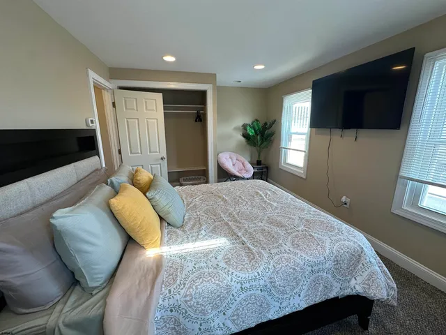 a bedroom with a bed a tv and wooden floor
