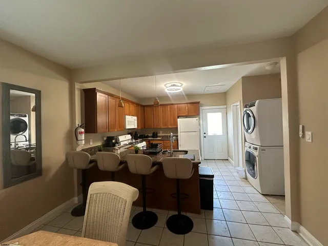 a view of a dining room and livingroom with furniture a rug a fireplace and windows