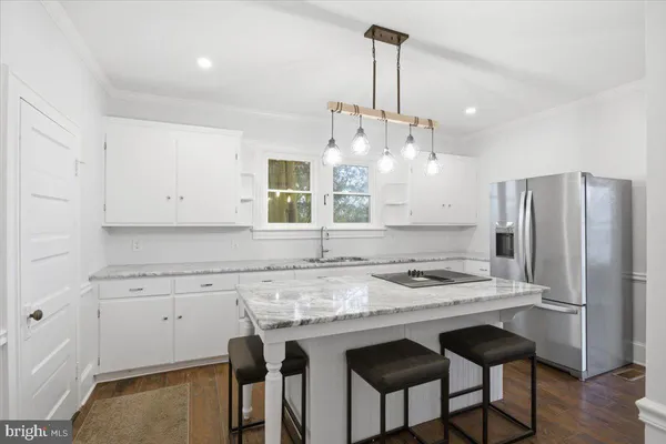 a kitchen with stainless steel appliances granite countertop a sink a stove a refrigerator and island