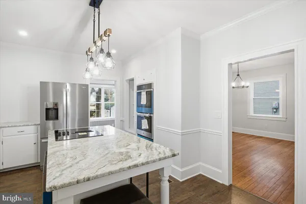 a view of a kitchen with granite countertop wooden floor and refrigerator