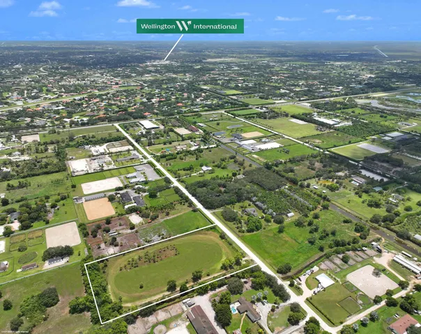 an aerial view of residential houses with outdoor space and trees