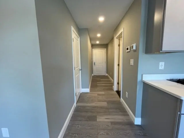 a view of a hallway with wooden floor