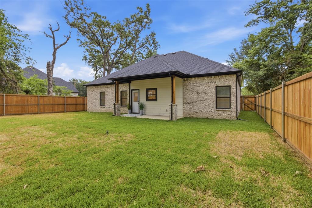 429 Waterboard Road Trinidad, TX 75163 - Photo 22 of 25 Spacious backyard featuring a wood privacy fence, a covered patio with wood columns, and a light brick and siding exterior