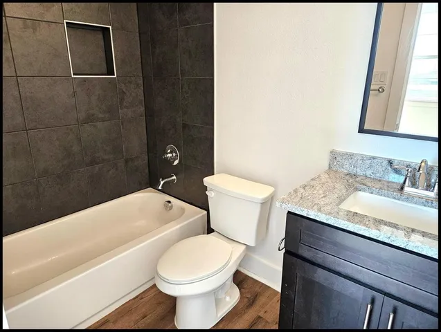 an empty room with wooden floor cabinet and windows