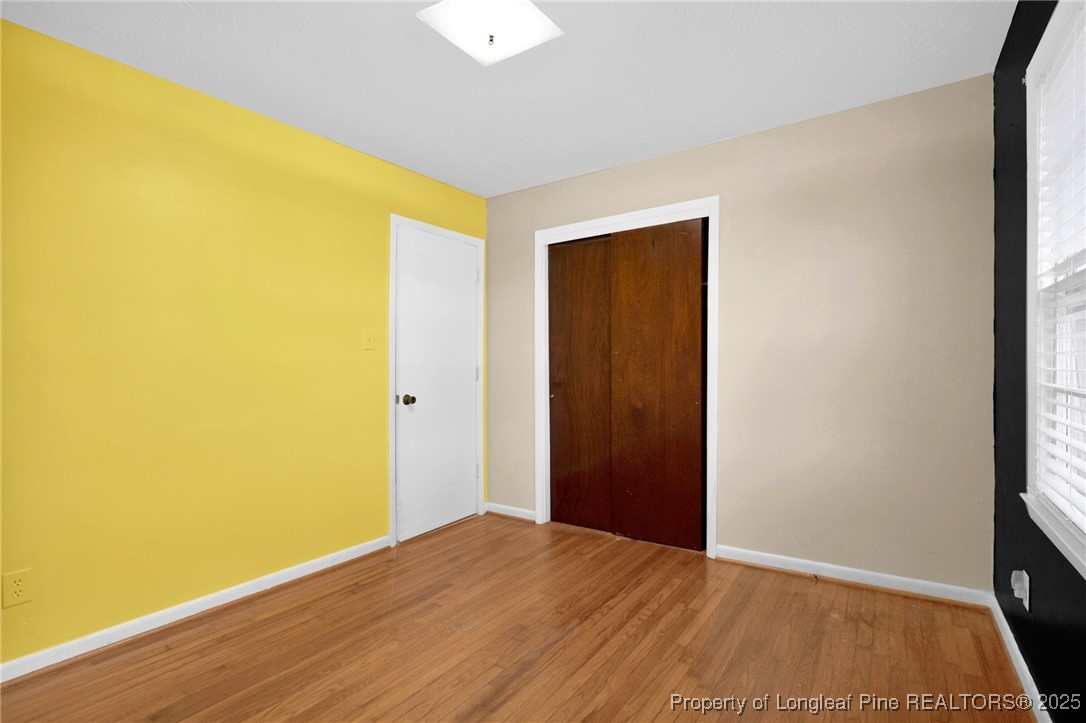 623 Isaac Weeks Road Clinton, NC 28328 - Photo 15 of 24 a view of an empty room with wooden floor and a window