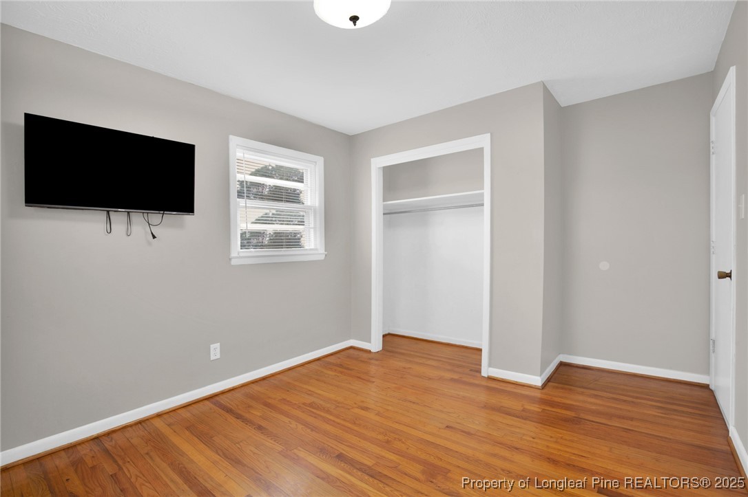 623 Isaac Weeks Road Clinton, NC 28328 - Photo 22 of 24 a view of empty room with wooden floor and flat screen tv
