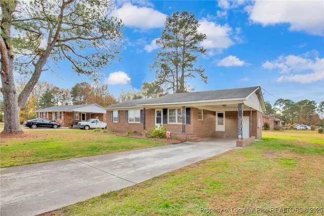 a front view of a house with a yard and trees