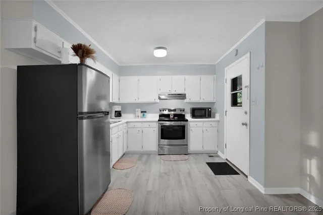a kitchen with white cabinets and stainless steel appliances