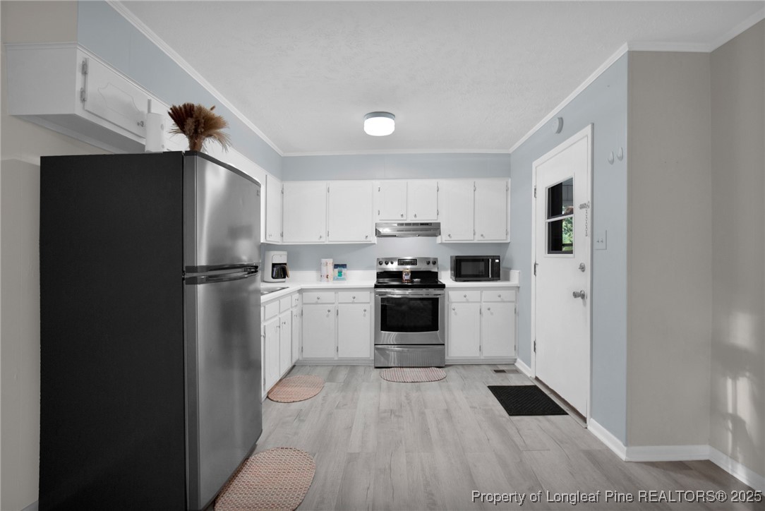 623 Isaac Weeks Road Clinton, NC 28328 - Photo 9 of 24 a kitchen with white cabinets and stainless steel appliances