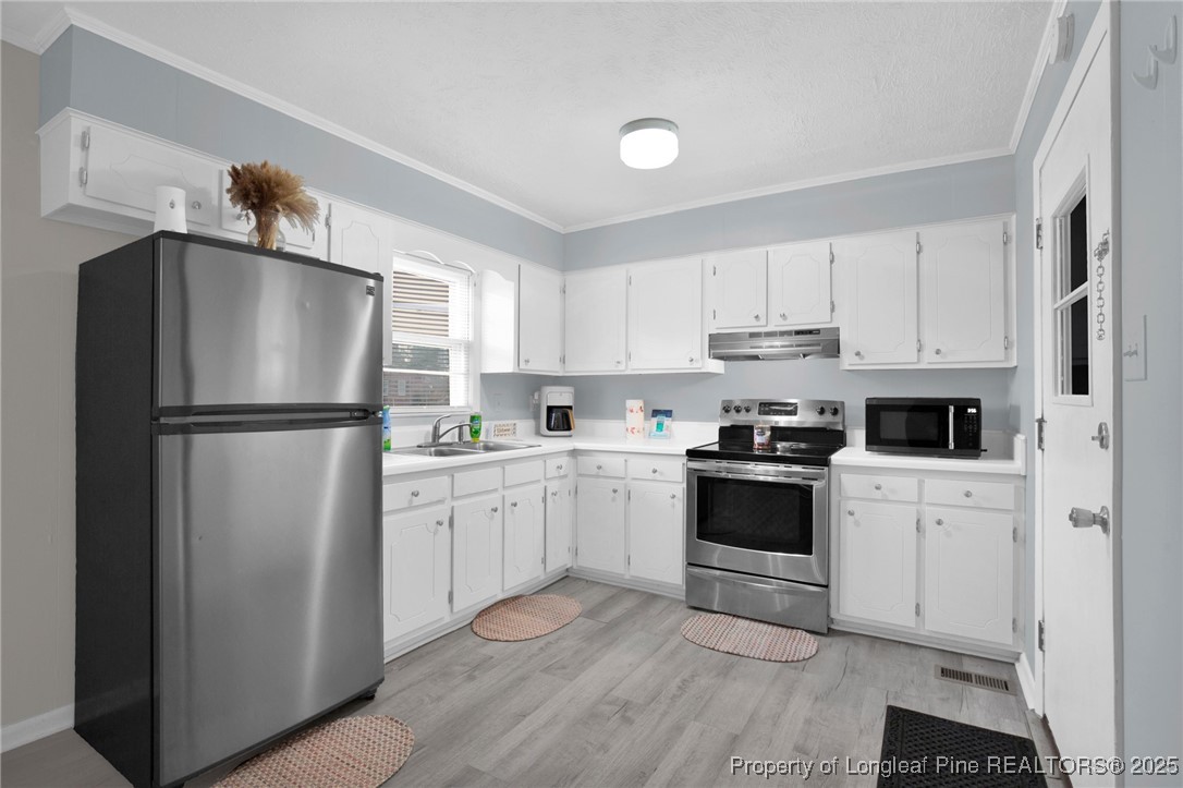 623 Isaac Weeks Road Clinton, NC 28328 - Photo 10 of 24 a kitchen with white cabinets and stainless steel appliances