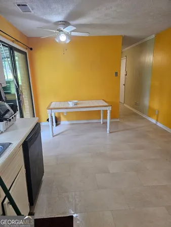 a view of an empty room with furniture and a window