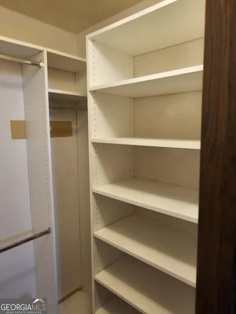 a view of walk in closet with empty racks