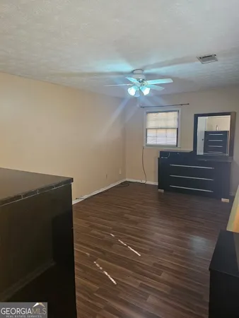 a view of room with hardwood floor and ceiling fan