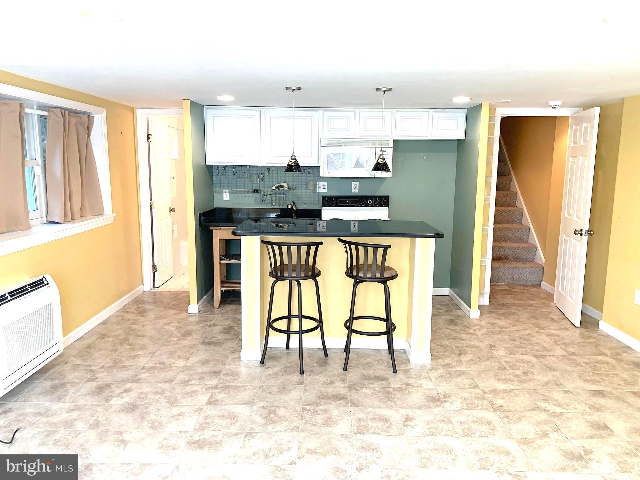 4459 MacArthur Boulevard Northwest, Unit LL Washington, DC 20007 - Photo 2 of 10 a kitchen with stainless steel appliances granite countertop a stove a refrigerator a sink a dining table and chairs with wooden floor